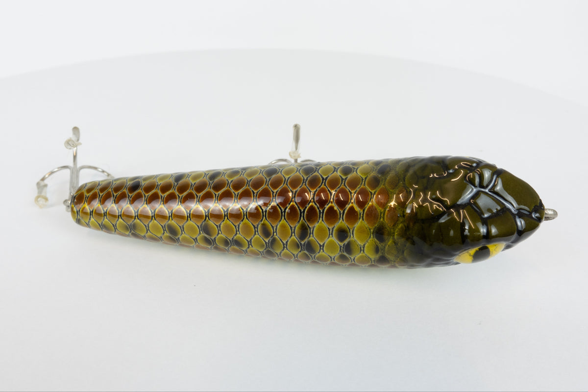 Bloodshot Raptor - Handmade Japanese Pencil Bait - Snake Skin pattern, new in original packaging, top view of fishing lure. 