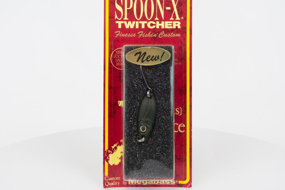 Megabass Spoon-X Twitcher - Mat Dark Green, discontinued Japanese made lure, new in original packaging, close up view.