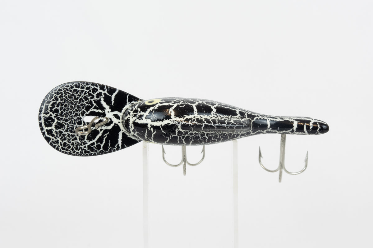 Heddon Crackleback 8000 WBC - White Black Crackle - vintage fishing lure from the USA in original packaging. Top view of lure on stand