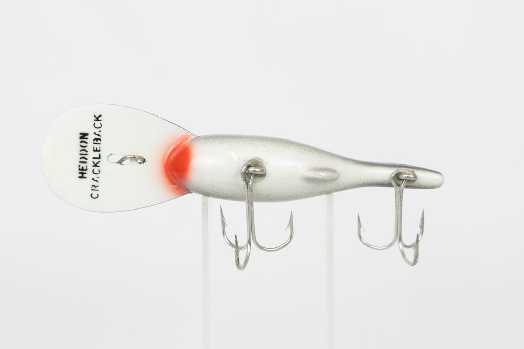 Heddon Crackleback 8000 WBC - White Black Crackle - vintage fishing lure from the USA in original packaging. Belly view of lure on stand
