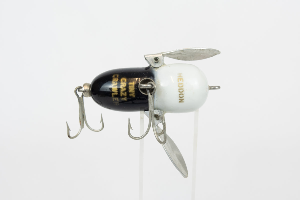 Heddon Tiny Crazy Crawler - BWH (Black, White Head) - Vintage lure in original packaging. Belly view of lure on stand. 