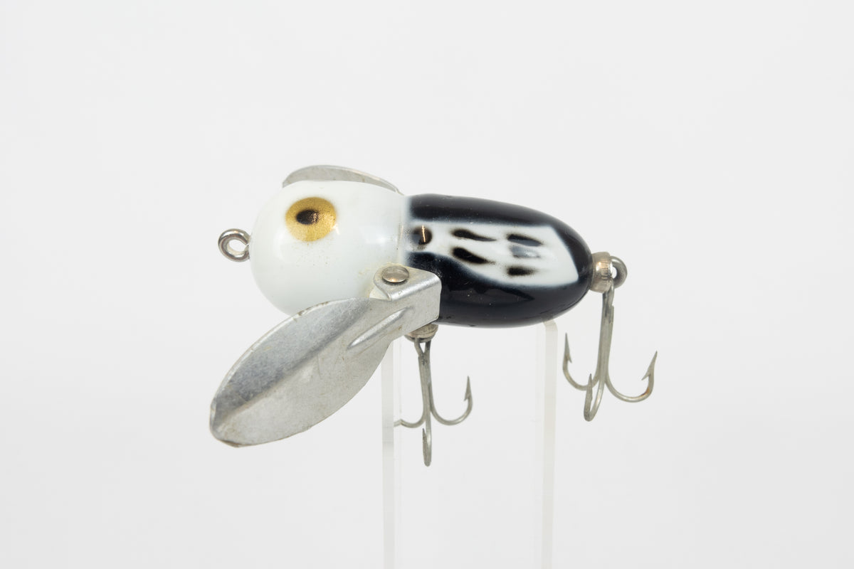 Heddon Tiny Crazy Crawler - BWH (Black, White Head) - Vintage lure in original packaging. Left side view of lure on stand. 